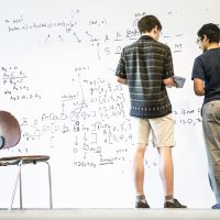 Two students in front of a whiteboard