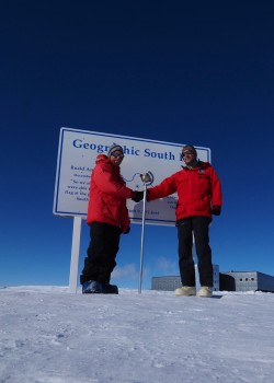 UW’s Eric Steig (left) and lead driller Jay Johnson of the University of Wisconsin shake hands at the geographic South Pole after completing the core Jan. 22. Since the ice sheet moves, this marker has to be placed each year.