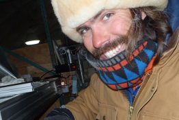 Author Bradley Markle examines a section of ice core at the West Antarctic field site. He spent two months in the field as a member of the drilling team.