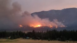 The Cedar Creek fire burns in Washington’s Methow Valley in late July 2021. Lucky Jim Bluff, near Mazama, is seen behind.