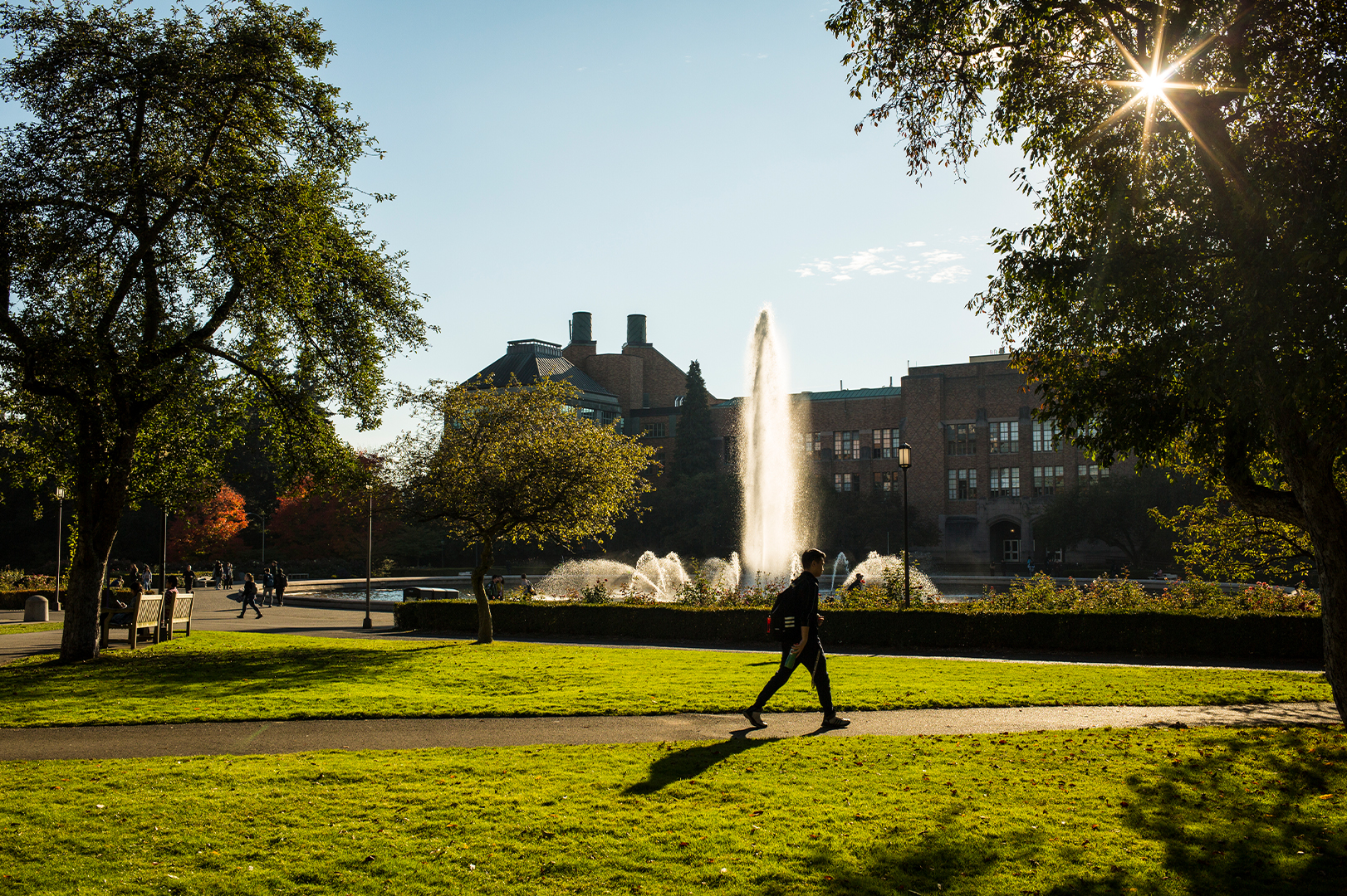 person walking in front of campus fountain
