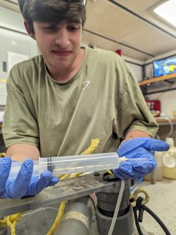 a student processes samples aboard a reseearch vessel