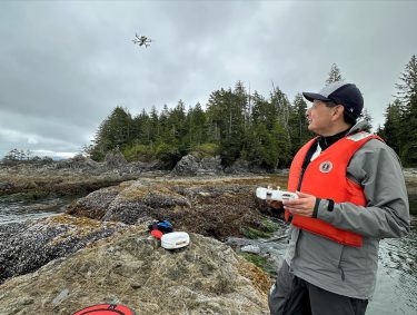 Corey Garza flies a drone for research in the field.