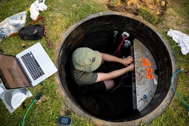 a person works underground to install a seismometer